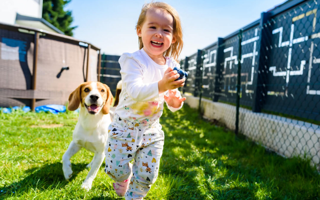 kiddo and dog in a backyard protected by an underground fence